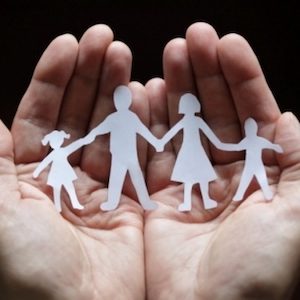 Family paper dolls held in palm of hands